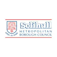 Logo du Solihull Metropolitan Borough Council représentant un écu rouge avec un lion et la devise latine Urbs in Rure, ainsi que le nom du conseil en texte bleu et gris.