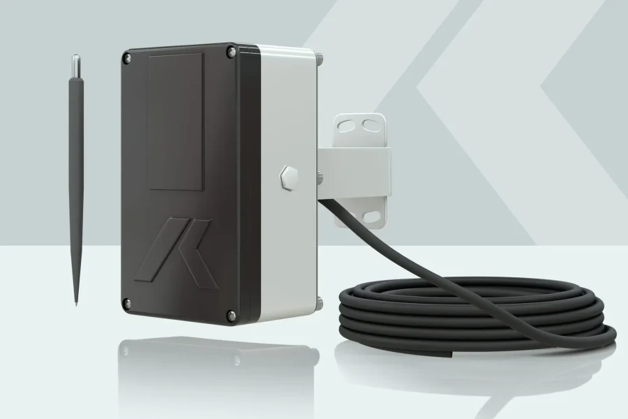 Un capteur électronique noir et blanc avec un long câble et une sonde métallique pointue, présenté sur un fond clair avec un motif géométrique.