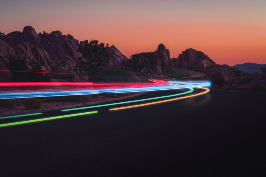 Vehicle light trails in mountain landscape at sunset