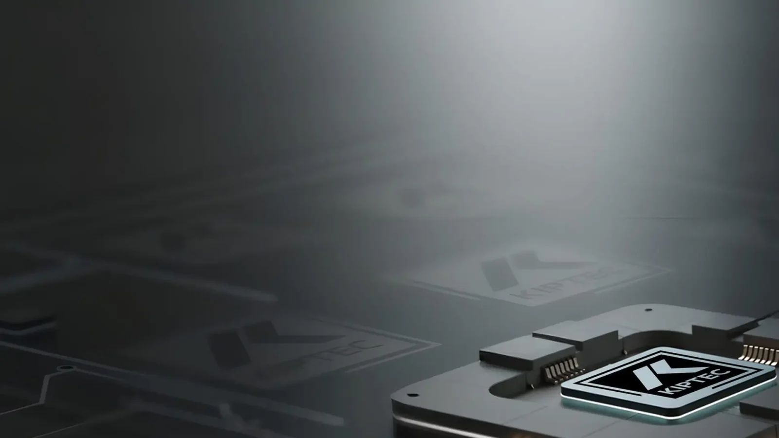 Gros plan d'un composant métallique de puce électronique portant le logo KIPTEC, sur un fond sombre et flou où l'on distingue des logos KIPTEC plus discrets.